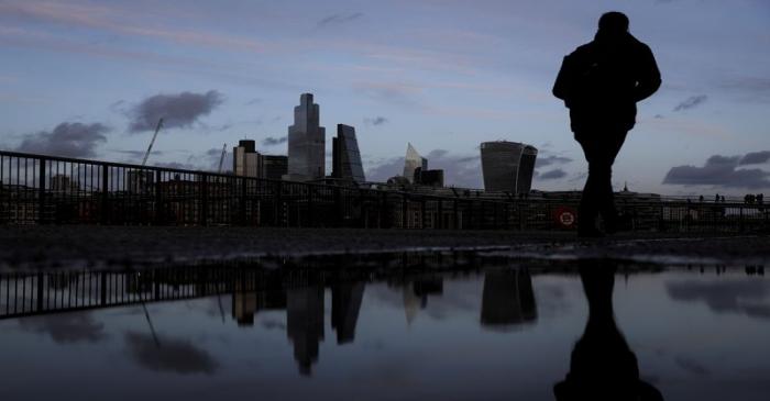 FILE PHOTO: Pedestrians walk along the Southbank in view of skyscrapers in the financial