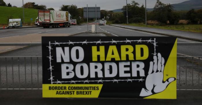 A lorry drives past a 'No Hard Border' poster near Londonderry, Northern Ireland