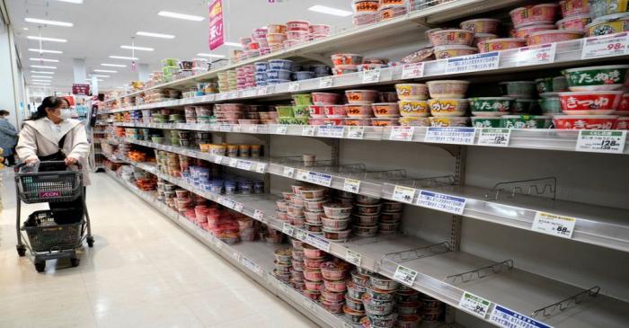 A shopper wearing a protective mask looks at shelves at a supermarket in Tokyo