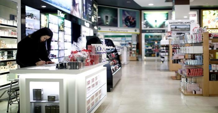 Employee of an empty duty free shop is pictured in Paris as the country is hit by the new