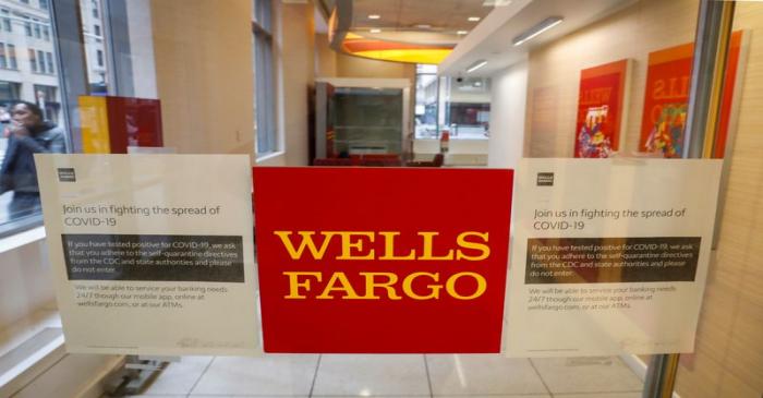 FILE PHOTO: Warning signs for coronavirus disease (COVID-19) are seen on a Wells Fargo bank