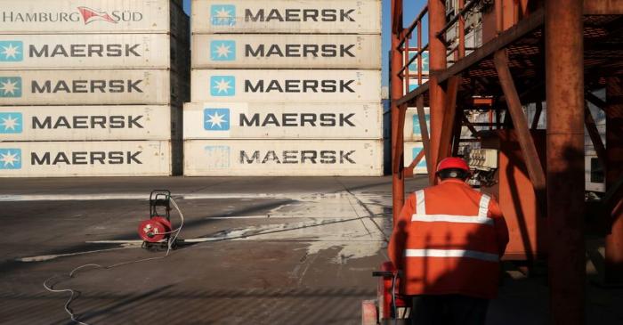 Worker is seen next to Maersk shipping containers at a logistics center near Tianjin por