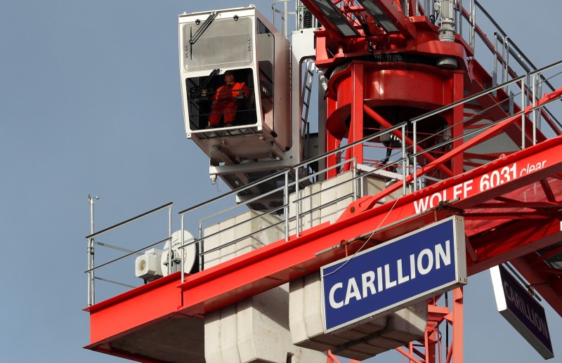 FILE PHOTO: A worker operates a crane on Carillion's Midland Metropolitan Hospital construction