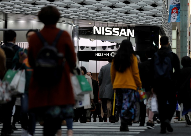 People walk past a Nissan Motor Co's showroom in Tokyo