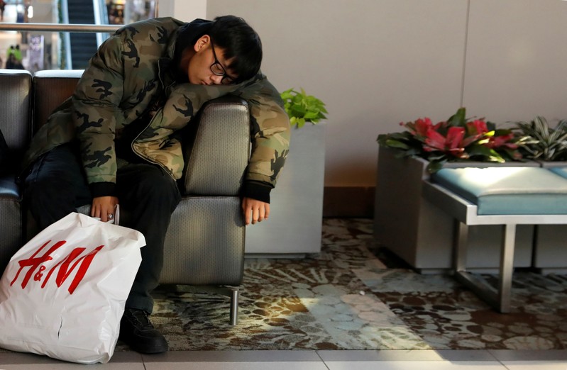 A person sleeps during the Black Friday sales shopping event at Roosevelt Field Mall in Garden