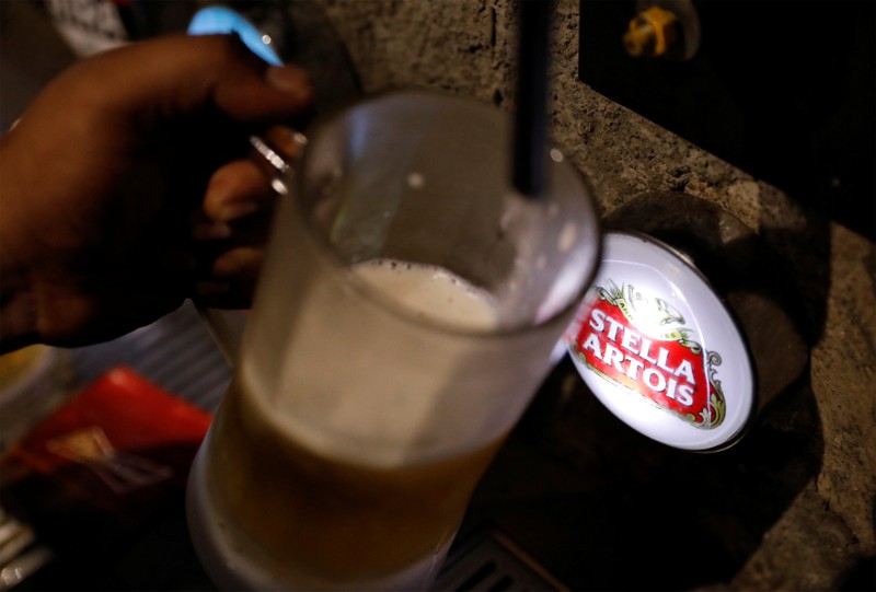 A waiter pours Stella Artois draught beer at a pub in Mumbai