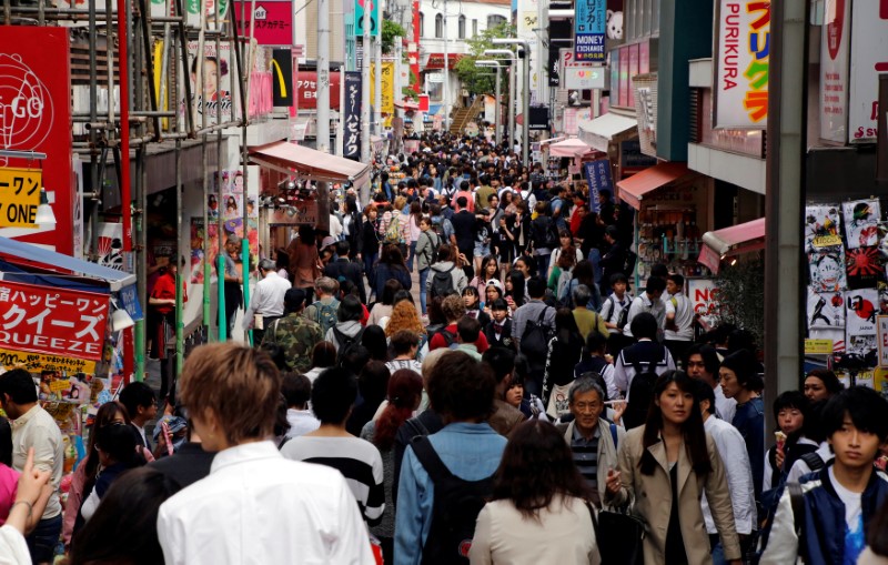 FILE PHOTO - People walk on a street in a busy shopping district in Tokyo