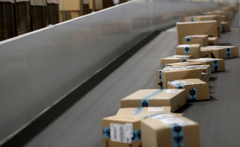 Packages are transported on a conveyor belt at the Amazon fulfillment center in the village of