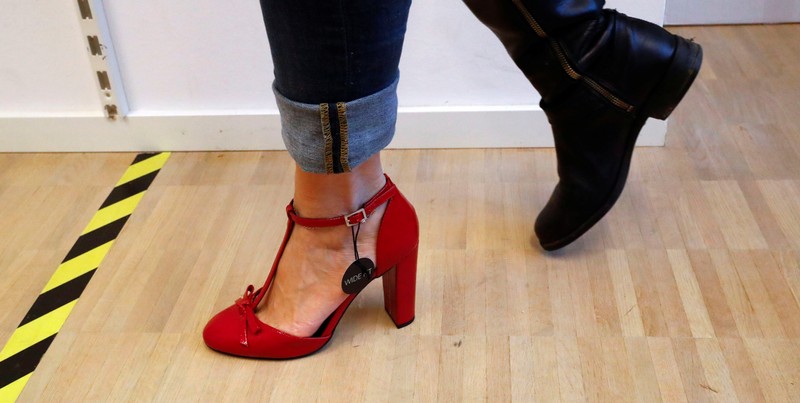 A fitting model checks out sizes for a shoe which goes on sale at the online shop of fashion