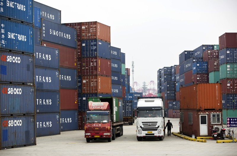 Trucks carrying containers drive at a port of Shanghai Free Trade Zone