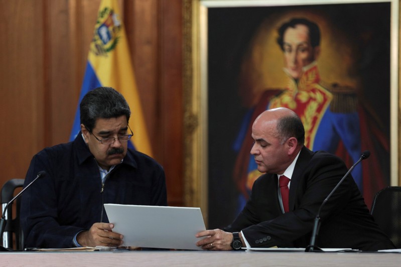 FILE PHOTO: Venezuela's President Maduro speaks with Venezuela's Oil Minister and President of