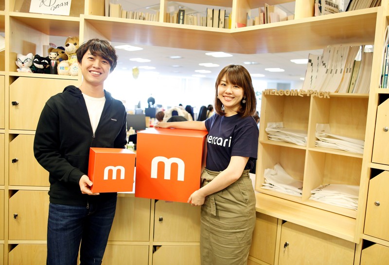 Employees of Mercari Inc. Takashi Murakami and Ayano Okuda pose for a photograph at the company