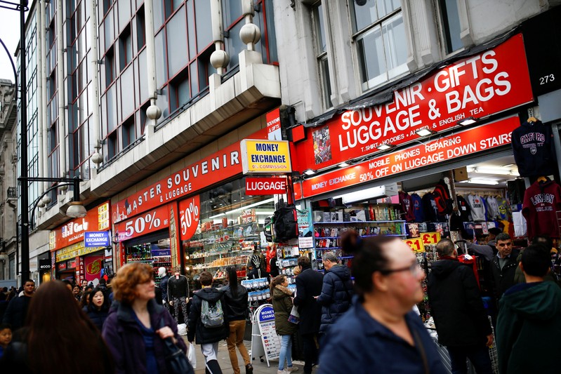 People walk past souvenir shops during the Boxing Day sales on Oxford Street in central London