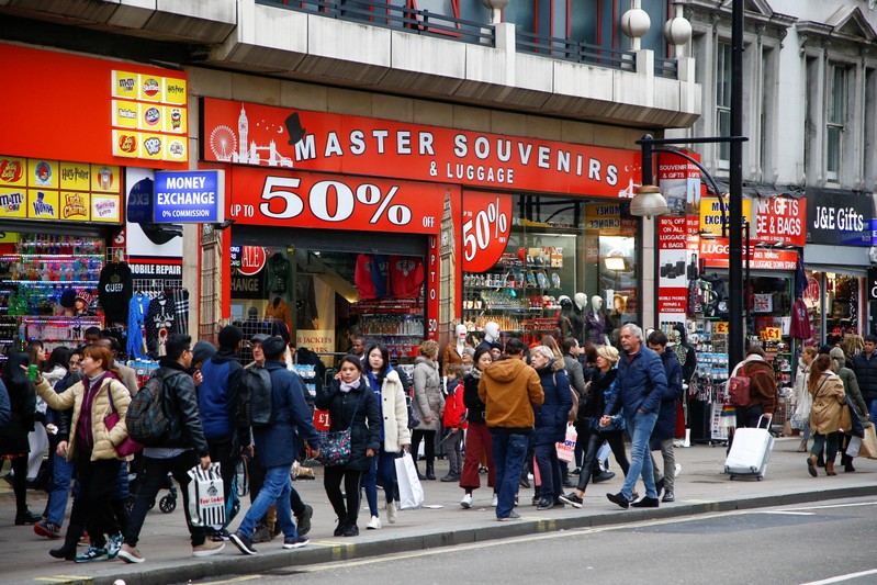 People walk past souvenir shops during the Boxing Day sales on Oxford Street in central London