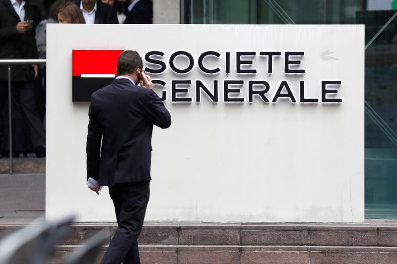 A man passes by the logo on the headquarters of French bank Societe Generale at the financial