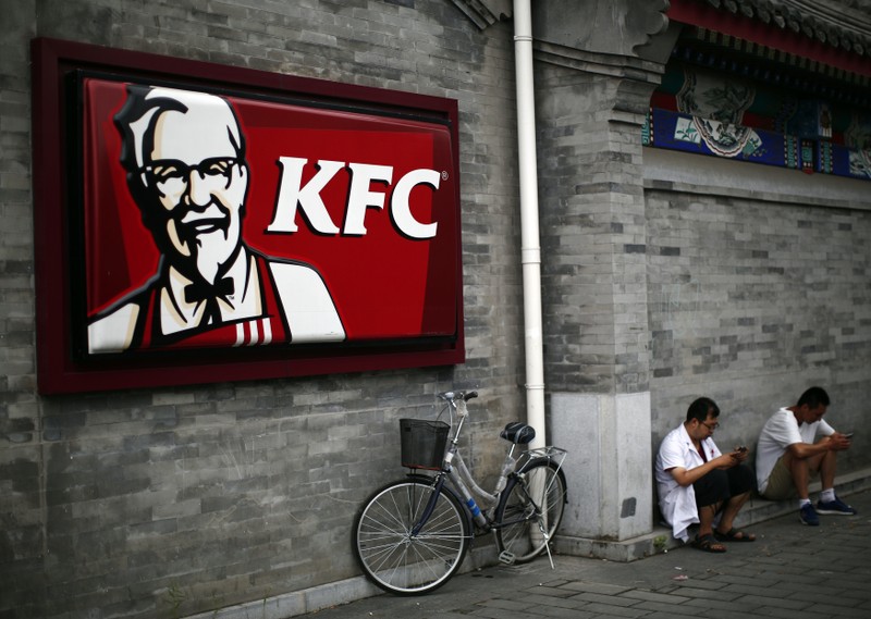 Men sits outside a KFC restaurant in Beijing