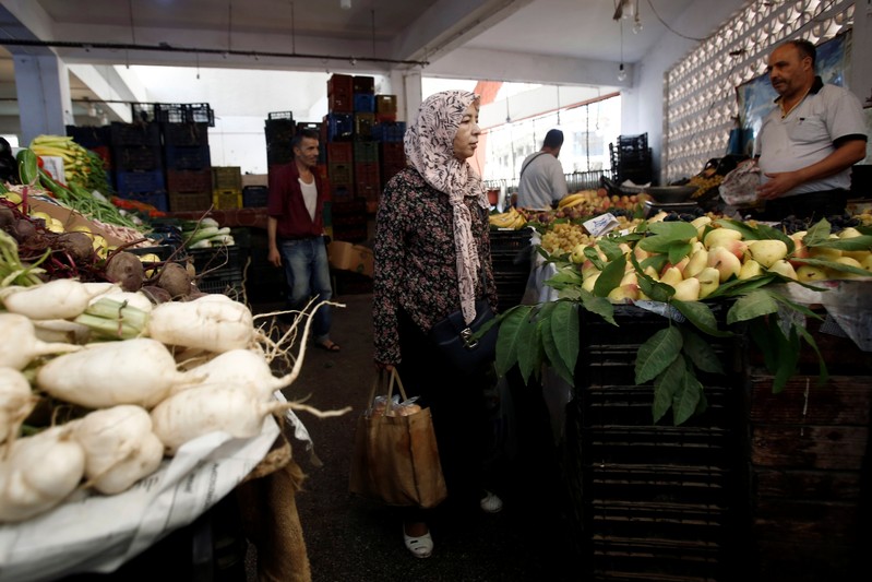 People shop for vegetables and fruits at a market in Algiers