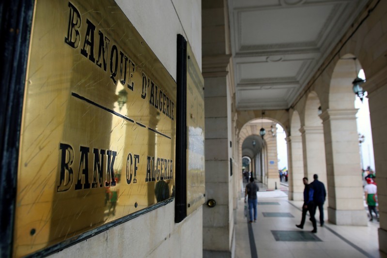 People walk past Bank of Algeria in Algiers