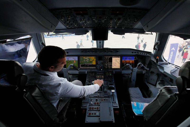 FILE PHOTO: A pilot sits in a cockpit of the Embraer E-195 E2 jet airliner at the MAKS 2019 air