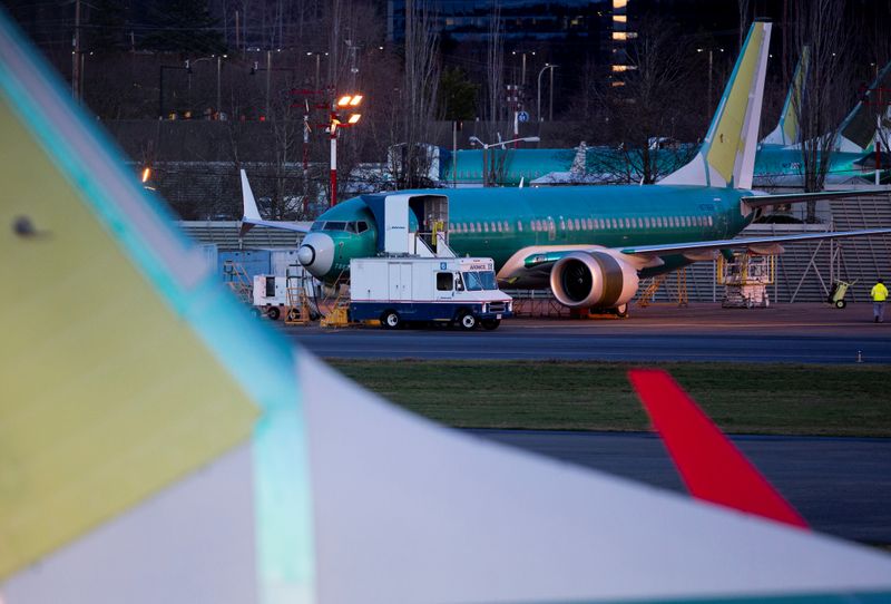 A service truck is seen stopped next to a Boeing 737 Max aircraft in storage at the Renton