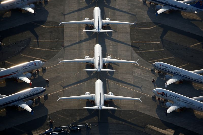 Employees walk past a Boeing 737 Max aircraft at Boeing's 737 Max production facility in Renton