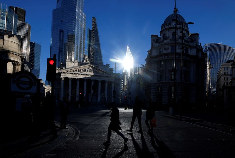 FILE PHOTO: Workers cross the road in the City of London, near the Royal Exchange and Bank of