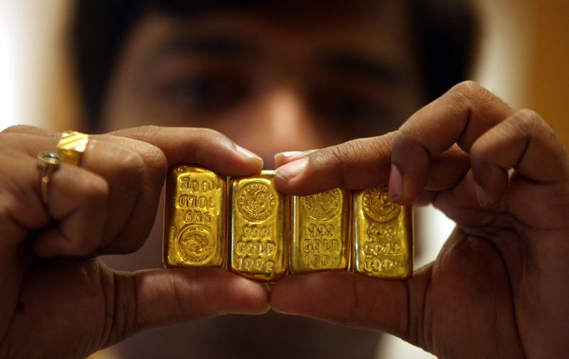 FILE PHOTO: A salesman displays gold bars inside jewellery shop on the occasion of Akshaya