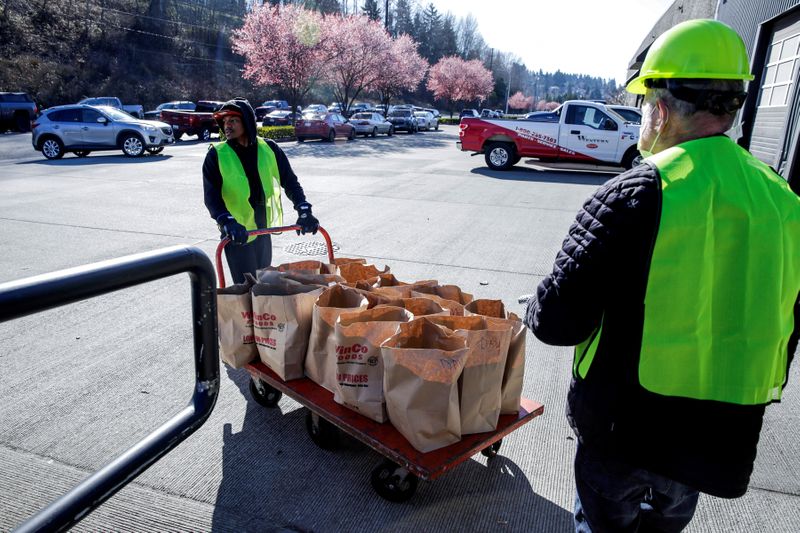 FILE PHOTO: Jovan Crump and John Peterson bring out bagged food donations