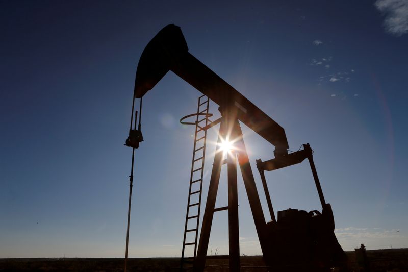 The sun is seen behind a crude oil pump jack in the Permian Basin in Loving County