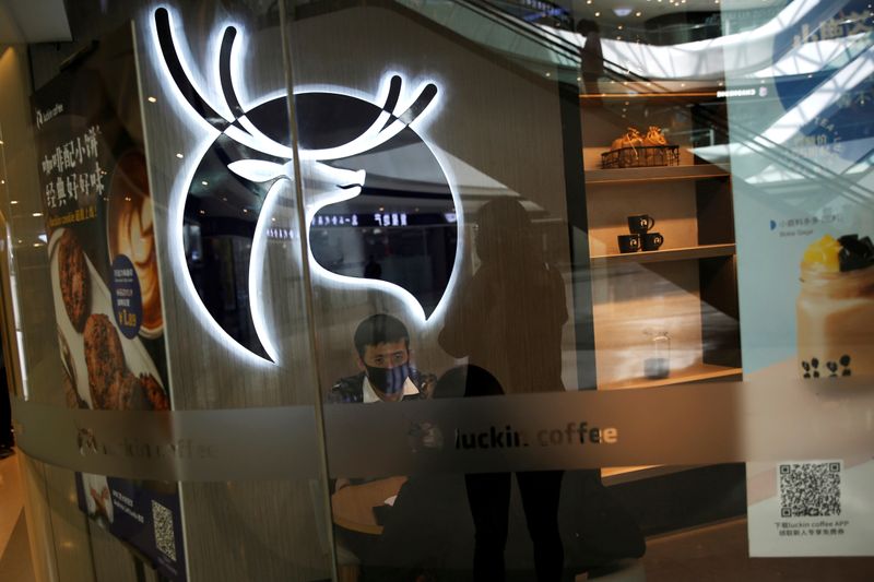 FILE PHOTO: Customers wearing face masks are seen inside a Luckin Coffee store in Beijing