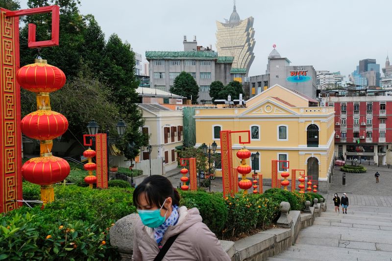 FILE PHOTO: People wear masks as they walk near the Ruins of St. Paul’s following the