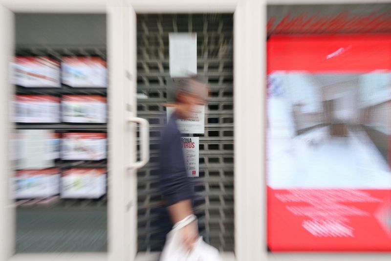 FILE PHOTO: A man walks past a real estate agency during the coronavirus disease (COVID-19)