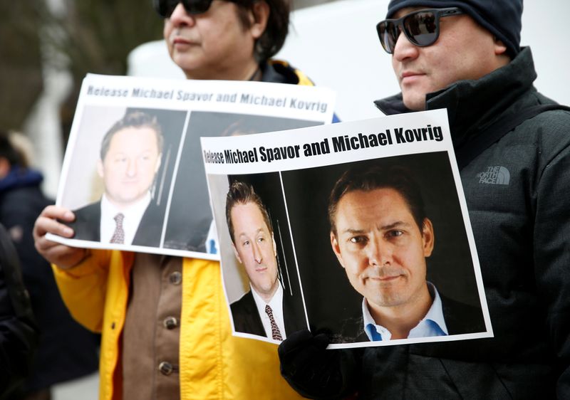 FILE PHOTO: People hold signs calling for China to release Canadian detainees Spavor and Kovrig