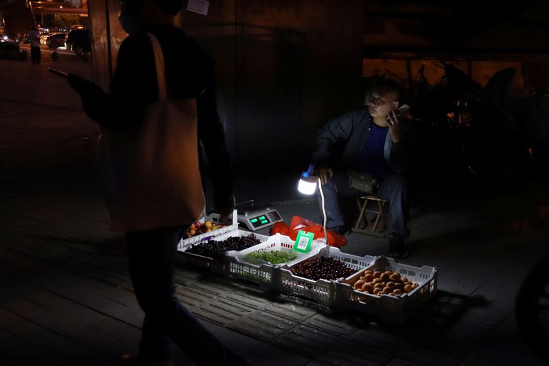 Street vendor waits for customers at his stall on a footbridge in Beijing