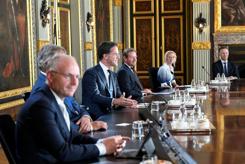 French President Emmanuel Macron and Dutch Prime Minister Mark Rutte speak in a restaurant, in