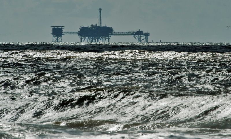 FILE PHOTO: Offshore drilling platforms (rear) stand together at a dock yard near Singapore