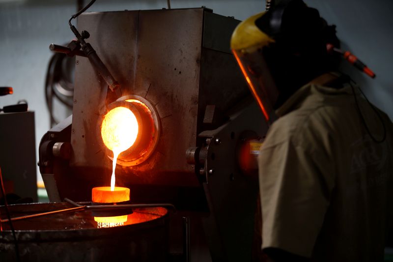 FILE PHOTO: An employee pours liquid gold into a mould for the production of an ingot during